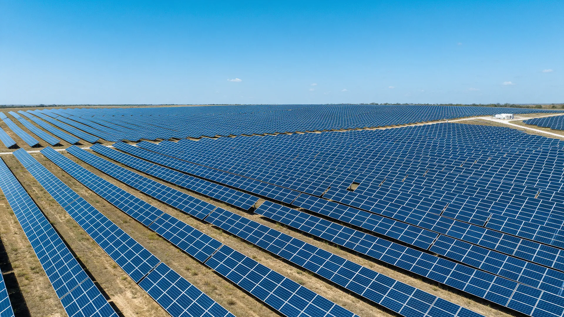 Aerial view of a large solar farm with rows of panels