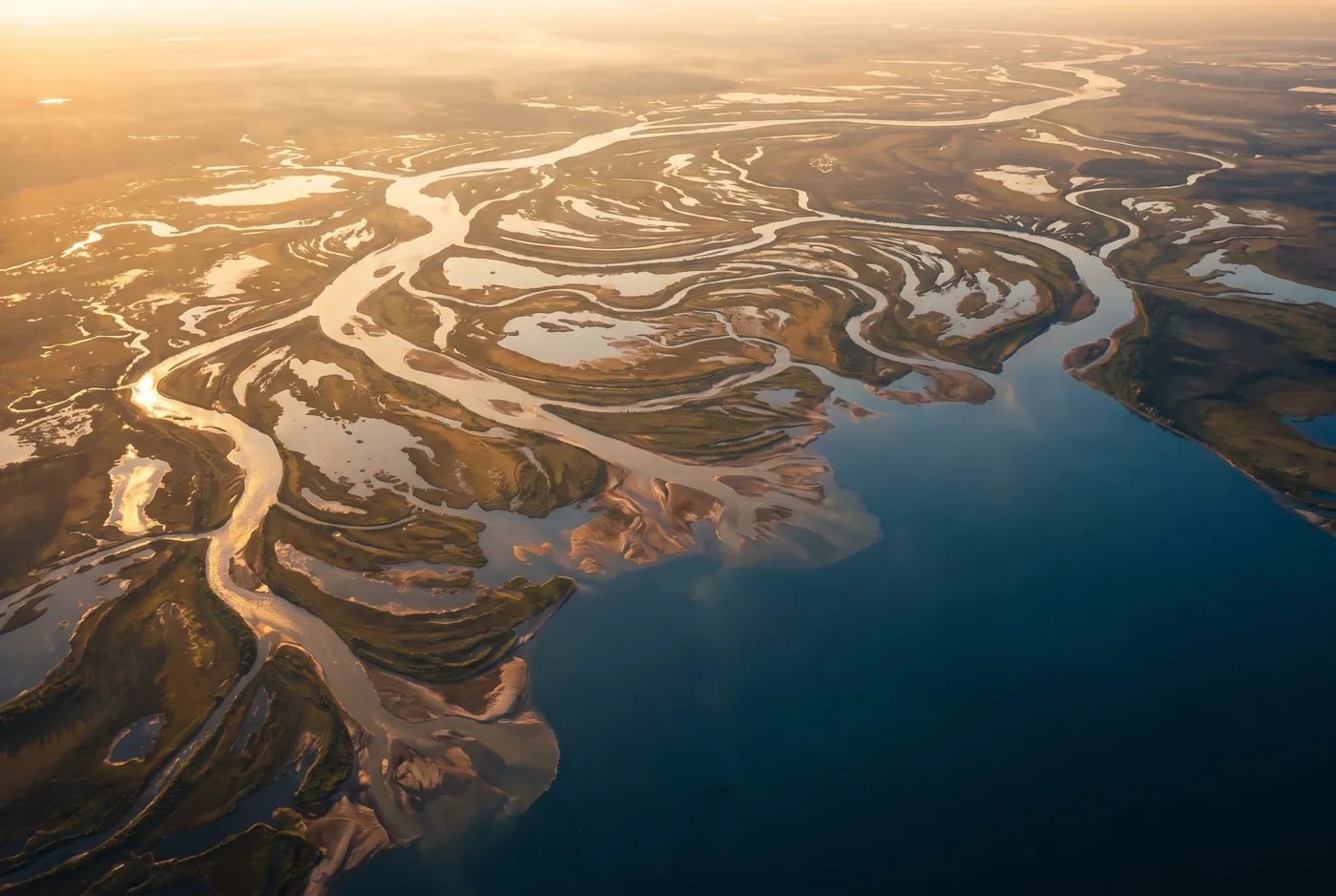 Aerial view of a river delta feeding a single deep blue reservoir
